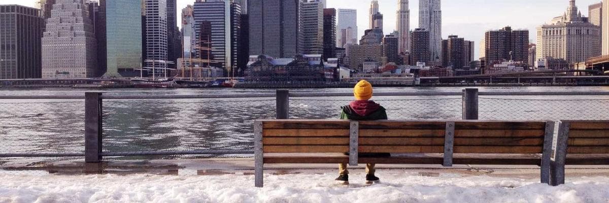 A stack of books and a plant on a desk.